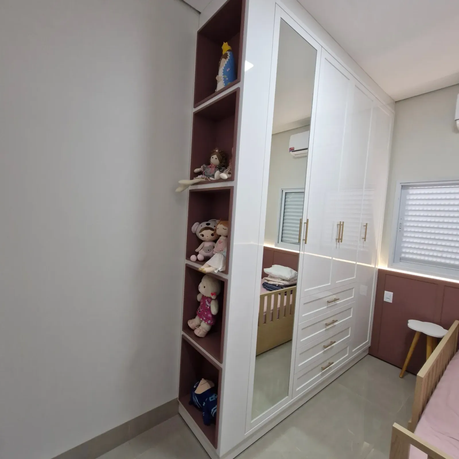 Quarto infantil planejado com guarda-roupa branco espelhado e nichos coloridos em Primavera do Leste